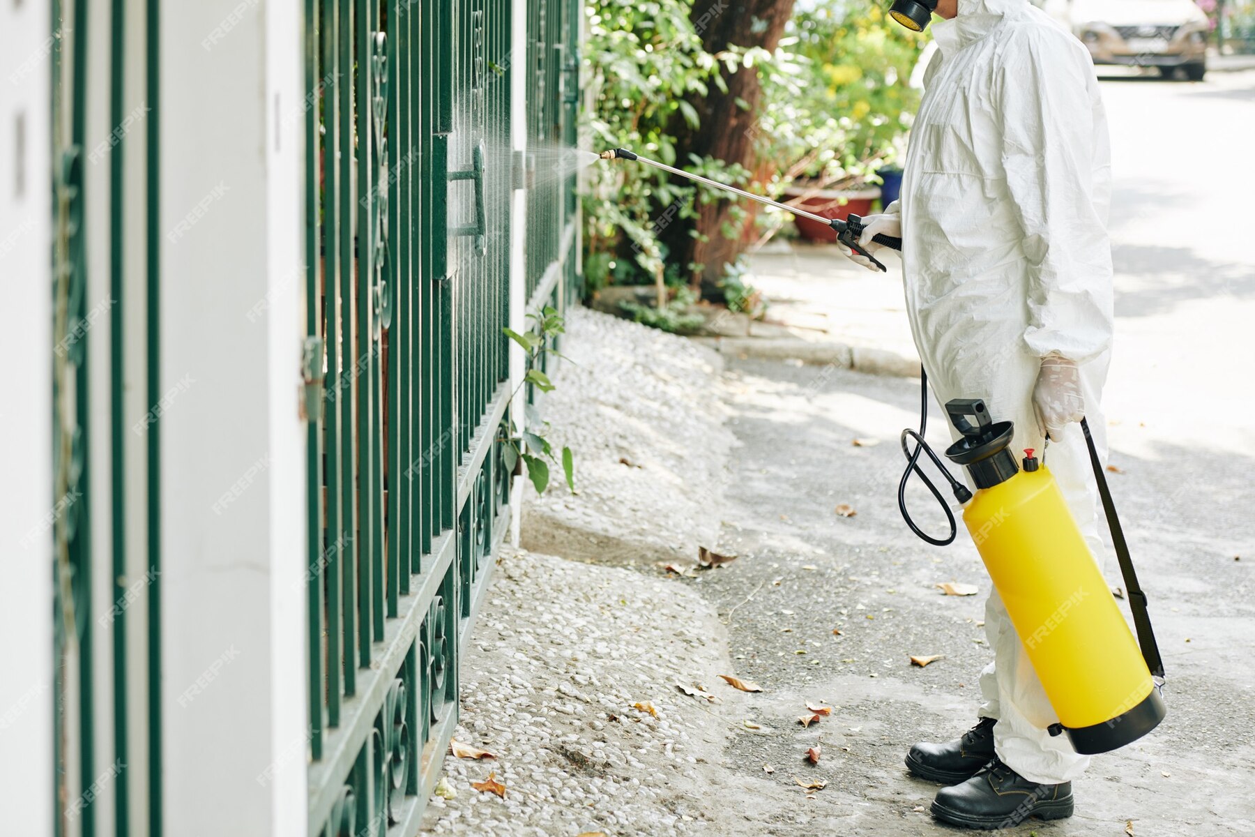 worker-disinfecting-fence_274689-13997