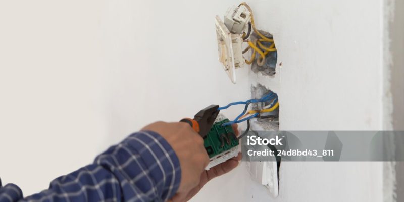 Electrician working at plug socket. Repair concept.