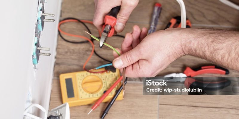 The electrician works at home, the electrician assembles the elements of the electrical installation of the house